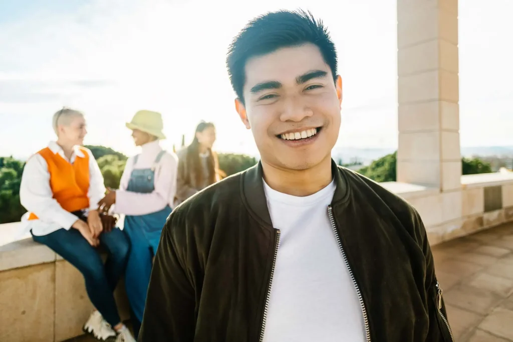 Man smiling with friends after restoring his smile with dentures from Southtown Family Dental in Kansas City, MO.