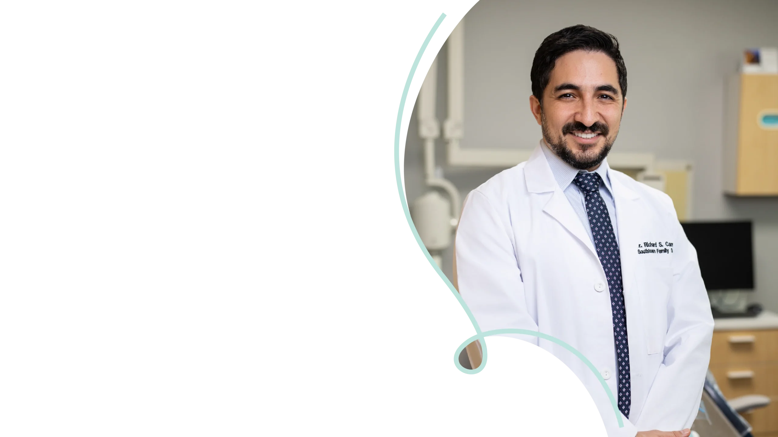 Dr. Richard Campos smiling in a white coat at Southtown Family Dental’s modern South Kansas City office.