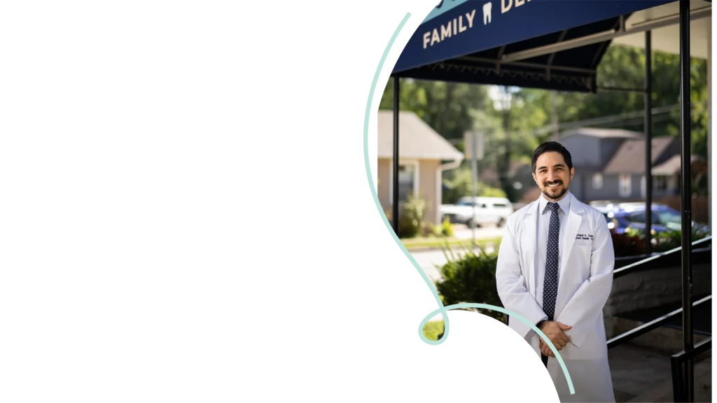 Dr. Richard Campos standing outside Southtown Family Dental in Kansas City, MO, beneath the blue practice awning.
