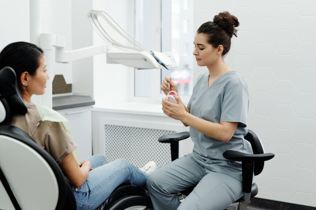 Dentist explaining a dental model to a patient during a first dental appointment.