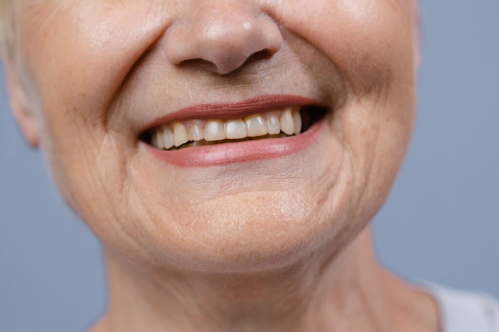 Close-up of a woman smiling confidently with healthy-looking teeth.
